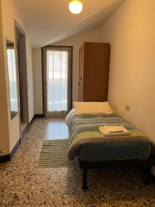Dormitorio pequeño con cama y armario en Hotel Aurora en Colico