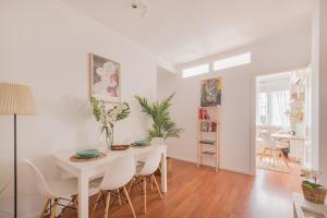 a white dining room with a white table and chairs at Brand new stylish ,spacious and cosy room with en suite bathroom in Madrid