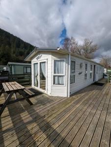 a white tiny house on a wooden deck at The Ashcroft in Dunoon