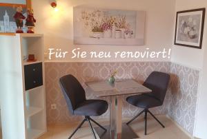 a table and two chairs in a room at Ferienwohnung Hameln Jasmin in Hameln +15 photos