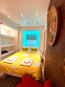 Un dormitorio con una cama amarilla con una foto en la pared en Apartamento no bairro alto 58, en Lisboa