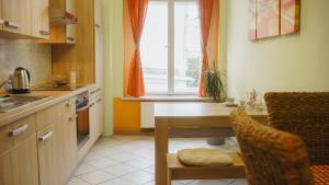 eine Küche mit einem Tisch, einem Waschbecken und einem Fenster in der Unterkunft Sylvias Ferienwohnung Nr2 in Görlitz