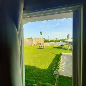 a view from a window of a yard with a field at Dija's holiday rental in Al Qaţā