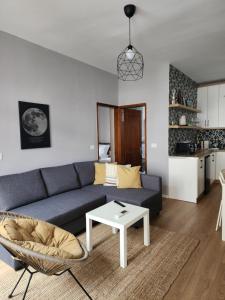 uma sala de estar com um sofá e uma mesa em Dhami Apartment em Gjirokastër