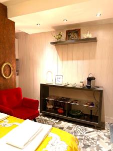 una sala de estar con una silla roja y un estante en Apartamento no bairro alto 58, en Lisboa