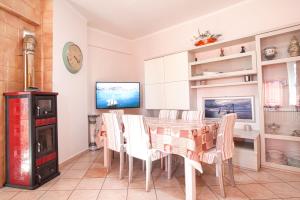 a dining room with a table and chairs and a tv at Oasi Verde in Castiglione Chiavarese