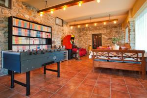 um quarto com uma mesa de pingue-pongue e uma estante de livros em Oasi Verde em Castiglione Chiavarese
