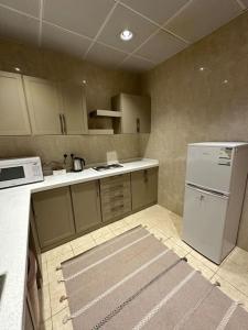 a kitchen with a white refrigerator and a stove at وحدة سكنية فاخرة 2 Luxury residential unit in Al Madinah