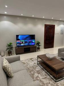 Il comprend un salon doté d'un canapé et d'une télévision à écran plat. dans l'établissement وحدة سكنية فاخرة 2 Luxury residential unit, à Médine