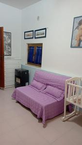 a purple bed in a white room with at Country House Gaeta in Gaeta