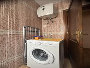 y baño pequeño con lavadora y secadora. en Apartamento vacacional Fuerteventura 1A, en Cotillo