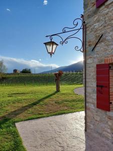 una puerta a un edificio con una lámpara y un campo en BORGO LE LANTERNE Locazione Turistica, en Follina