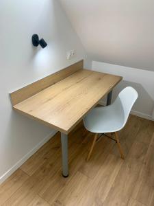 a wooden desk with a white chair next to it at Appartement Cosy, Résidence de l’Ecluse in Arques