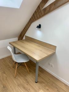 a wooden table and a chair in a room at Appartement Cosy, Résidence de l’Ecluse in Arques