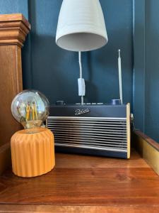 an old radio and a lamp on a wooden table at Glenesk No 1 , Woodhall Spa in Woodhall Spa +64 photos