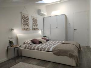 a white bedroom with a large bed and a white cabinet at Villa Ulika in Fažana