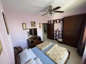 a bedroom with a bed and a ceiling fan at Andrea apartment in Saranda in Sarandë