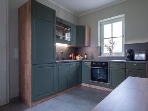 a kitchen with green cabinets and a window at Moserhof in Wahlhausen