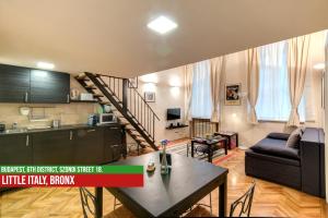 een keuken en een woonkamer met een tafel en een bank bij Little Italy Bronx Apartment in Boedapest