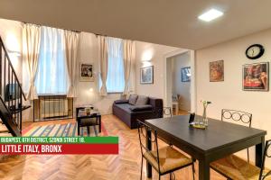een woonkamer met een tafel en een bank bij Little Italy Bronx Apartment in Boedapest