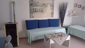 Zimmer mit einem Bett mit blauen Kissen und einem Tisch in der Unterkunft Country House Gaeta in Gaeta