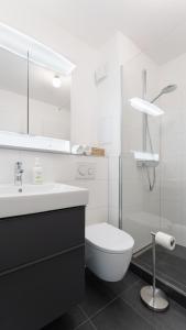 a white bathroom with a toilet and a sink at HomeSweetHome Wedel in Wedel