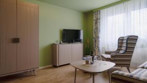 a living room with a tv and a table and chairs at HomeSweetHome Wedel in Wedel