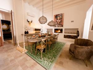 a dining room with a table and chairs and a fireplace at Casa Timbale in Felanitx