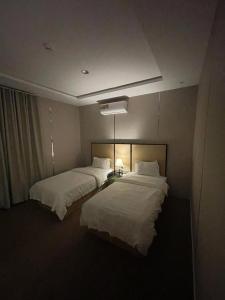 a hotel room with two beds and a light at شاليهات حديقة الوسام in Taif