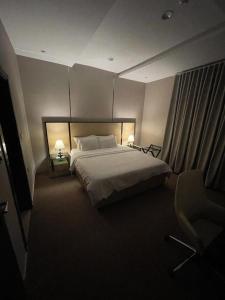 una camera con un grande letto e due lampade di شاليهات حديقة الوسام a Taif