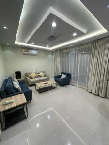 a living room with two blue couches and a table at شاليهات حديقة الوسام لبيوت العطلات 1 in Taif
