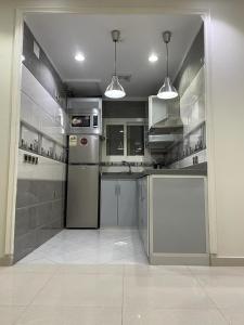 una cocina con electrodomésticos de acero inoxidable y armarios grises en شاليهات حديقة الوسام en Taif