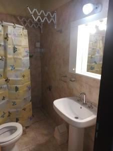 a bathroom with a sink and a toilet and a mirror at Alojamiento turístico NFG in San Carlos de Bariloche