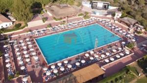 an overhead view of a large swimming pool with umbrellas at casavacanzekastalia in Ragusa