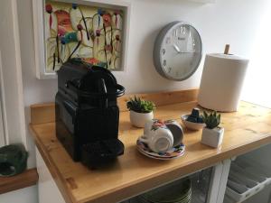 - une cafetière sur une table en bois avec une horloge dans l'établissement casetta del sole, à Otrante