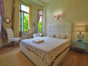 sypialnia z dużym białym łóżkiem i oknem w obiekcie Chateau Leconte w Salonikach