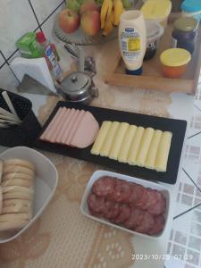 una mesa cubierta con queso, carne y otros alimentos en Kitnet OKTOBERFEST, en Blumenau