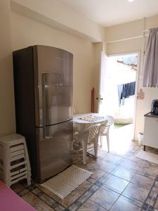 eine Küche mit einem Kühlschrank aus Edelstahl und einem Tisch in der Unterkunft Kitnet OKTOBERFEST in Blumenau