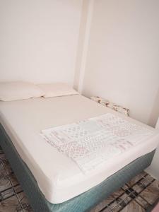 a bed in a room with a white mattress at Kitnet OKTOBERFEST in Blumenau