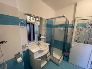 a blue and white bathroom with a sink and a shower at Andrea apartment in Saranda in Sarandë