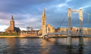 a bridge over a river in front of a city at Bed on the Brae in Inverness +2 photos