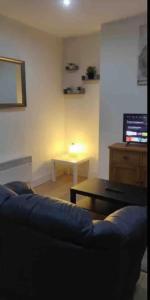 a living room with a blue couch and a table at *Cosy 1 bedroom apt nxt to Roundhay and centre * in Roundhay