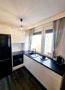 a kitchen with a sink and a black counter top at Apartament Ustecka Syrenka in Ustka