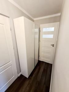 une pièce vide avec un placard blanc et une porte dans l'établissement Apartament Ustecka Syrenka, à Ustka