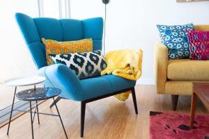 a blue chair and a couch in a living room at Solana Beach Sol condo in Solana Beach