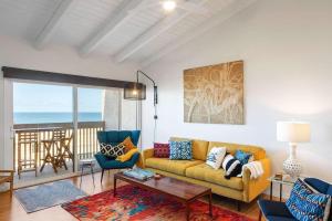 a living room with a yellow couch and a table at Solana Beach Sol condo in Solana Beach