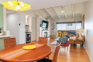 a dining room and living room with a wooden table at Solana Beach Sol condo in Solana Beach