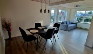 a dining room with a table and chairs in a living room at Annes Hus in Rødekro