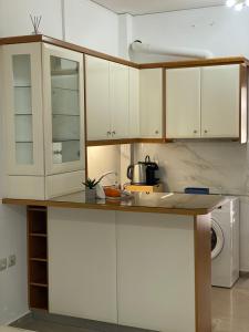 Una cocina con gabinetes blancos y encimera. en The Lemon Breeze Studio, en Tolo