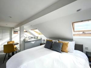 a bedroom with a large white bed with pillows at Seascape - Stylish Modern apartment in Barton on Sea